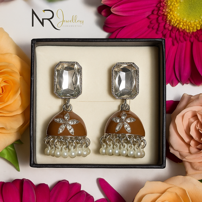 Jewelry box with decorative earrings surrounded by flowers