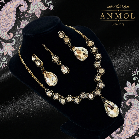 Jewelry set with necklace and earrings on a black velvet stand, branded 'Anmol Jewelry'.