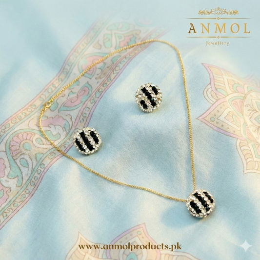 Jewelry set with necklace and earrings on a decorative fabric background, featuring the brand 'Anmol'.