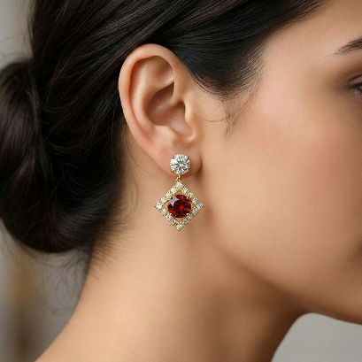 Close-up of a woman wearing a diamond and red gemstone earring.