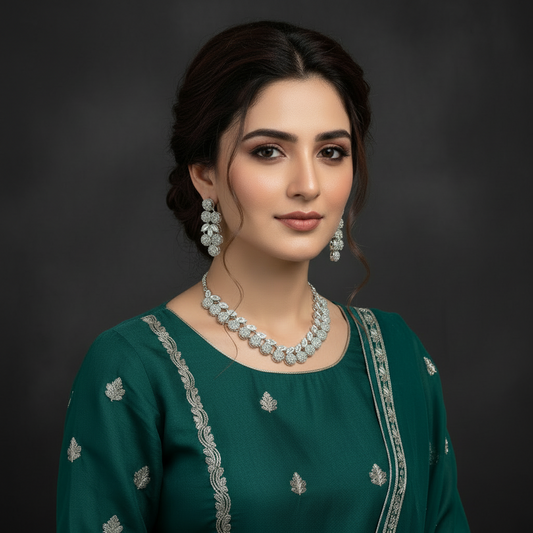 Woman wearing a green traditional outfit with silver jewelry against a dark background